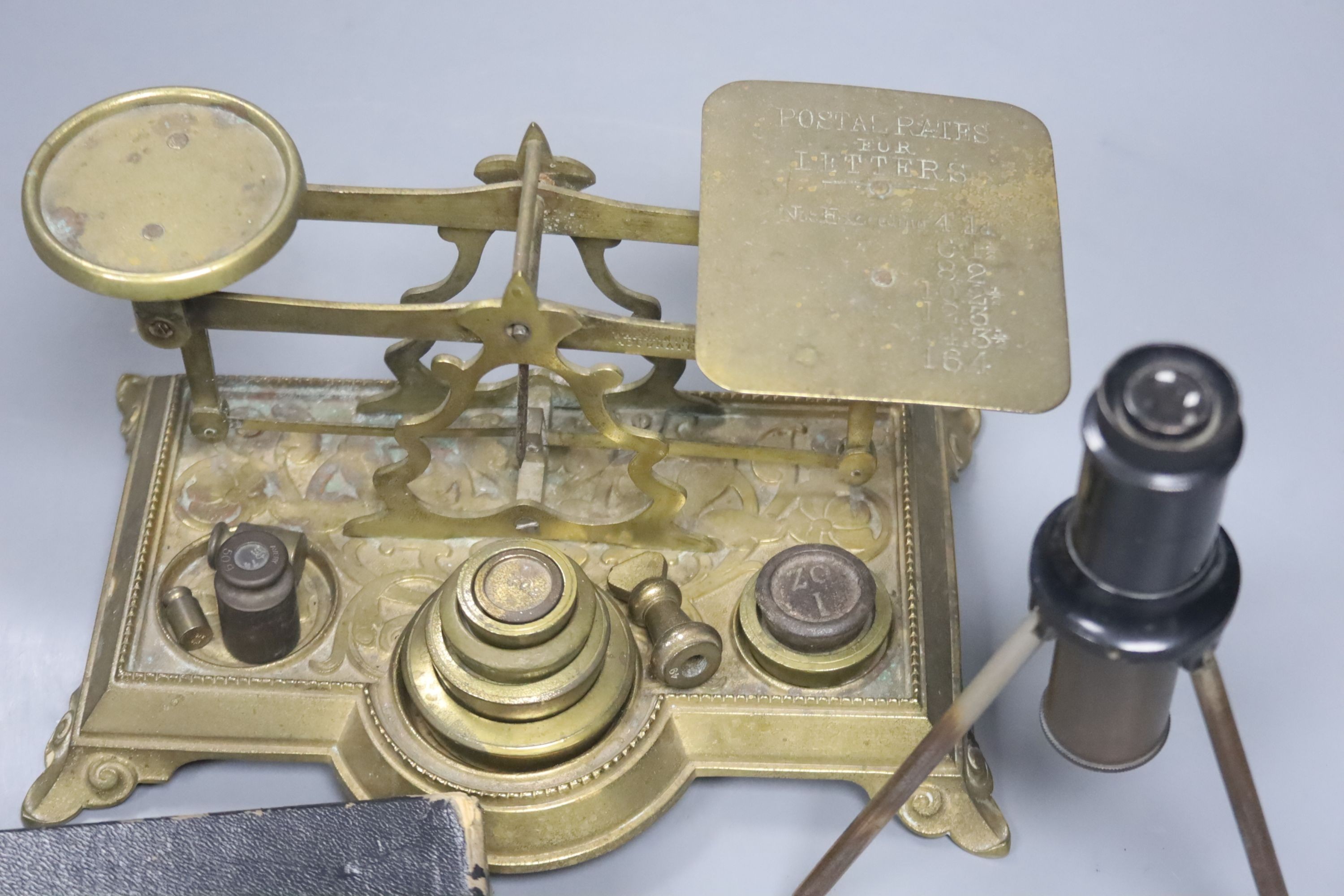 An Otis King's pocket calculator, a Voigtlander scope and brass postal scales